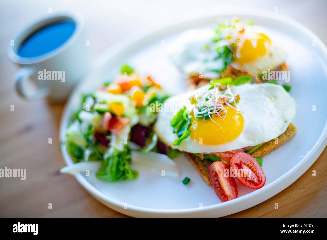 Breakfast with fried eggs on toasts on a restaurant table Stock Photo