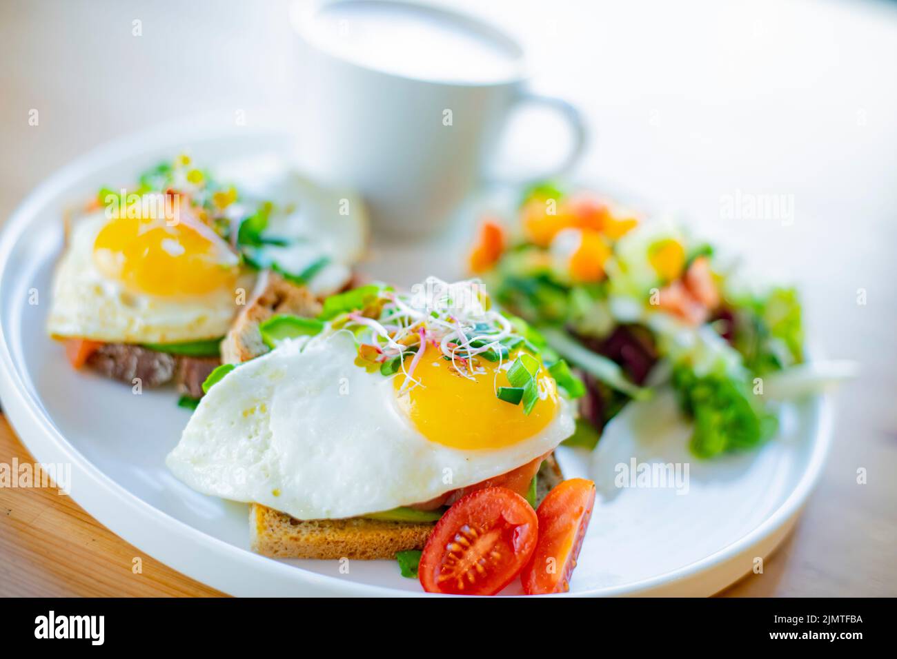 Breakfast with fried eggs on toasts on a restaurant table Stock Photo
