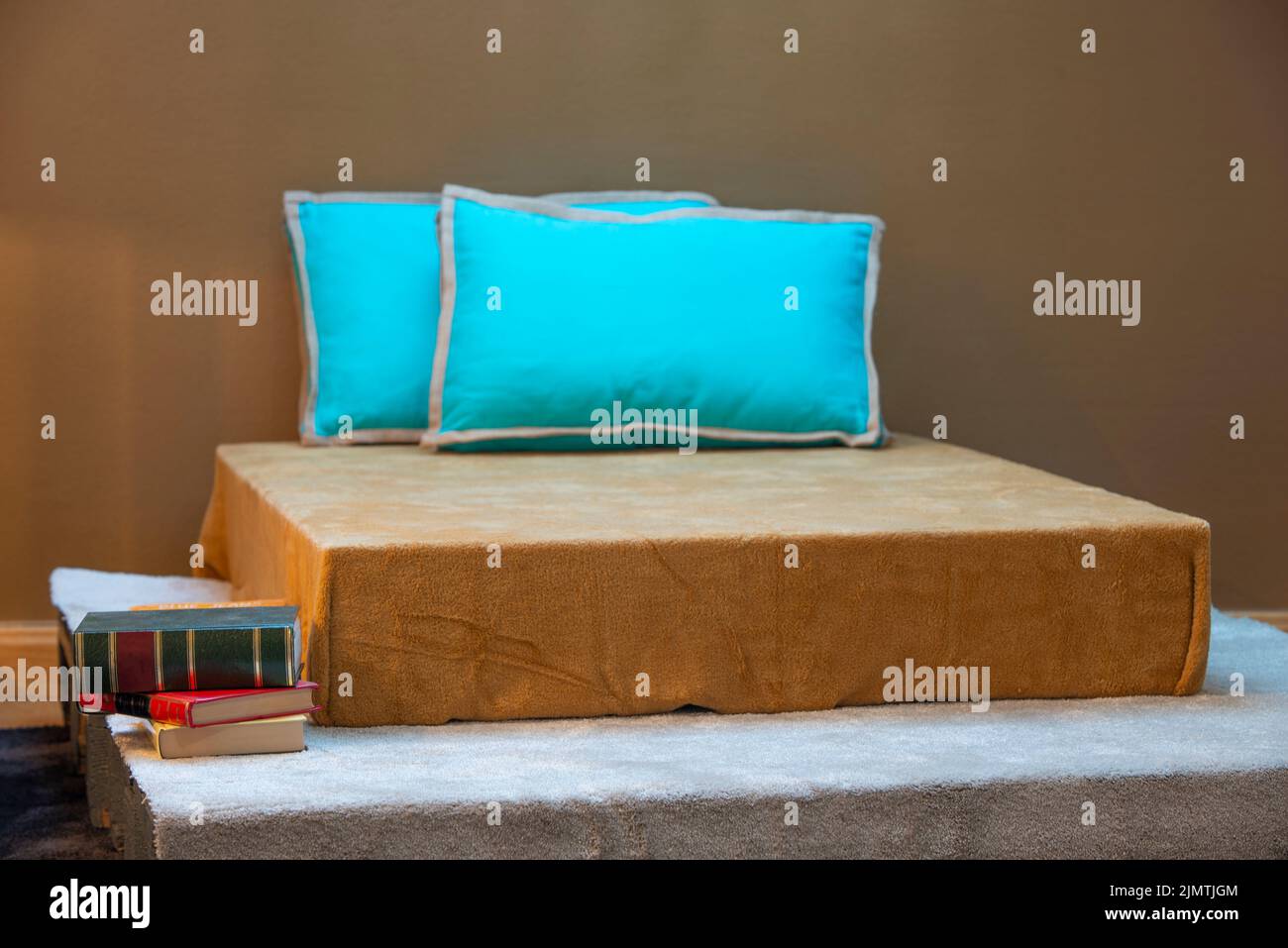 Bedroom reading nook with wing chair, bamboo floor lamp, blue books and
