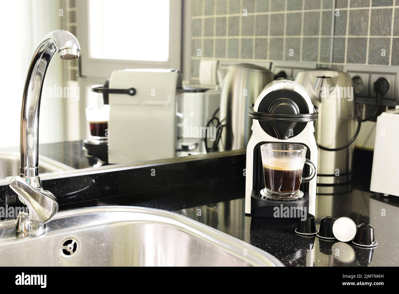 Kitchen of a small apartment with natural gas stoves, wooden countertops and access to a toilet