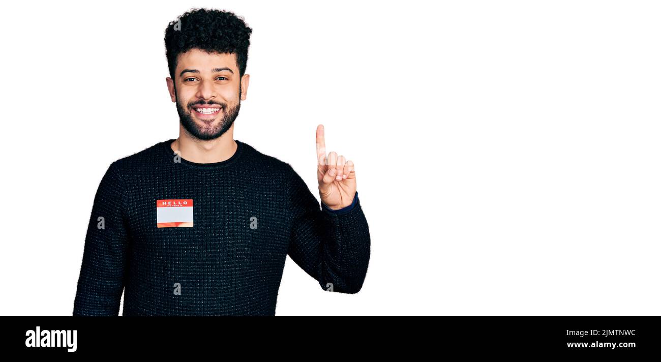 Young arab man with beard wearing hello my name is sticker ...