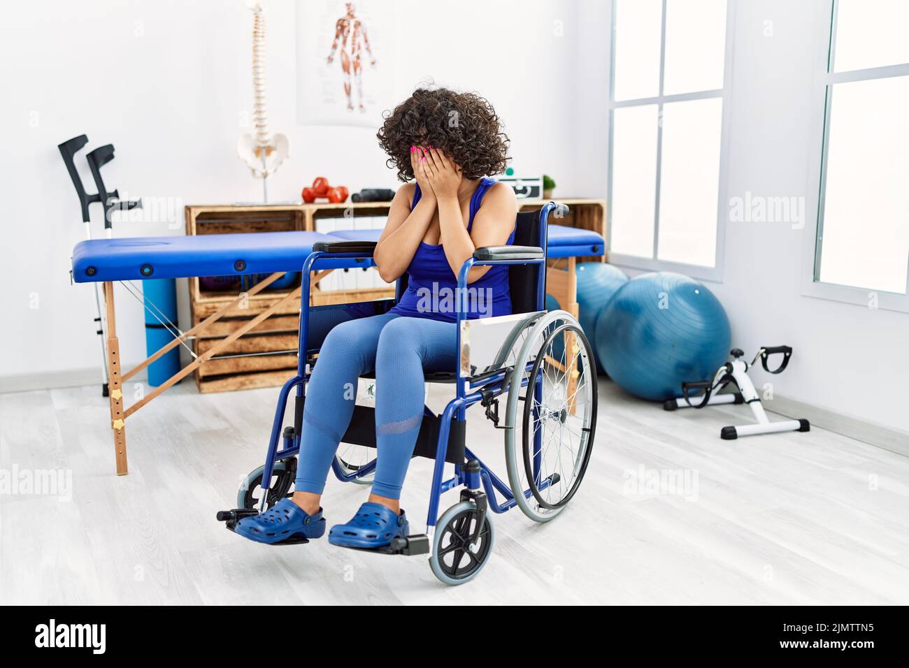 Young middle eastern woman sitting on wheelchair at physiotherapy