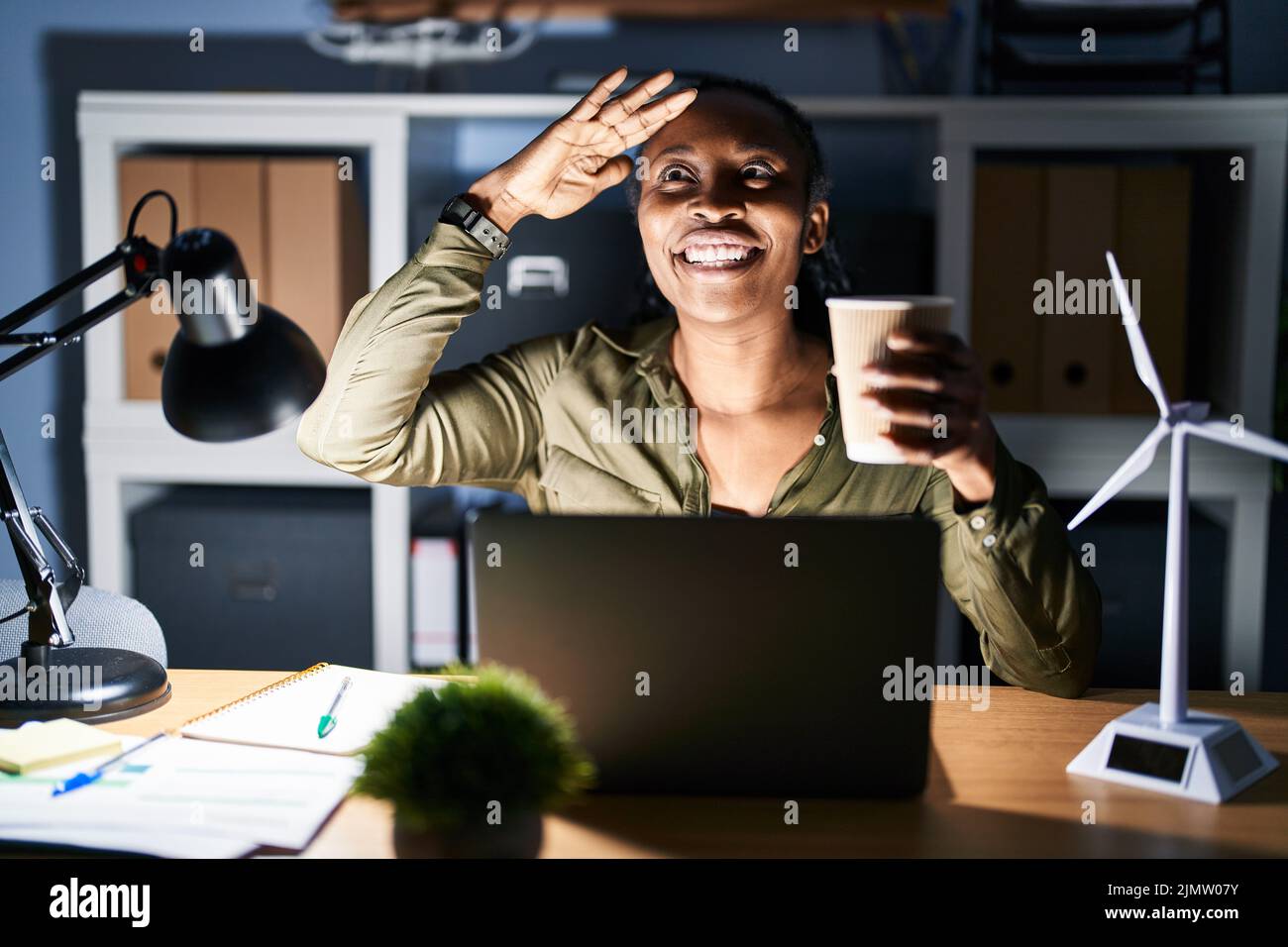 African woman working using computer laptop at night very happy and ...