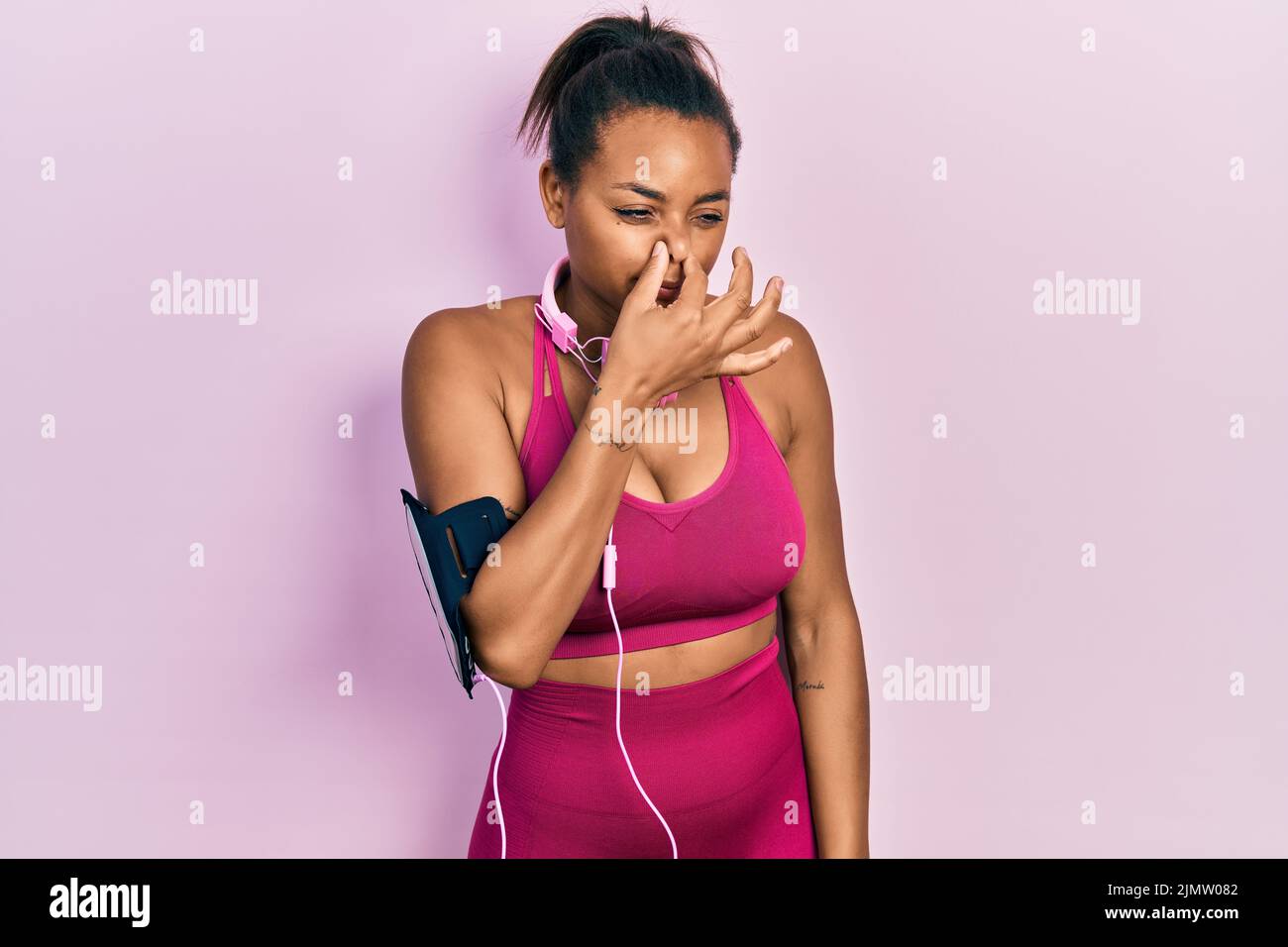Young african american girl wearing gym clothes and using headphones