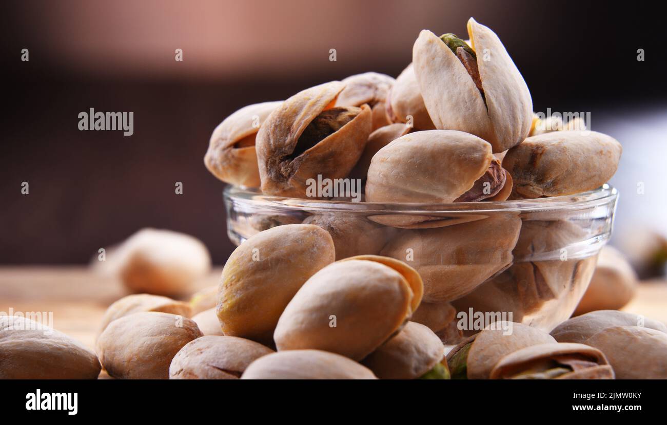 Composition with bowl of in shell pistachios. Delicacies Stock Photo