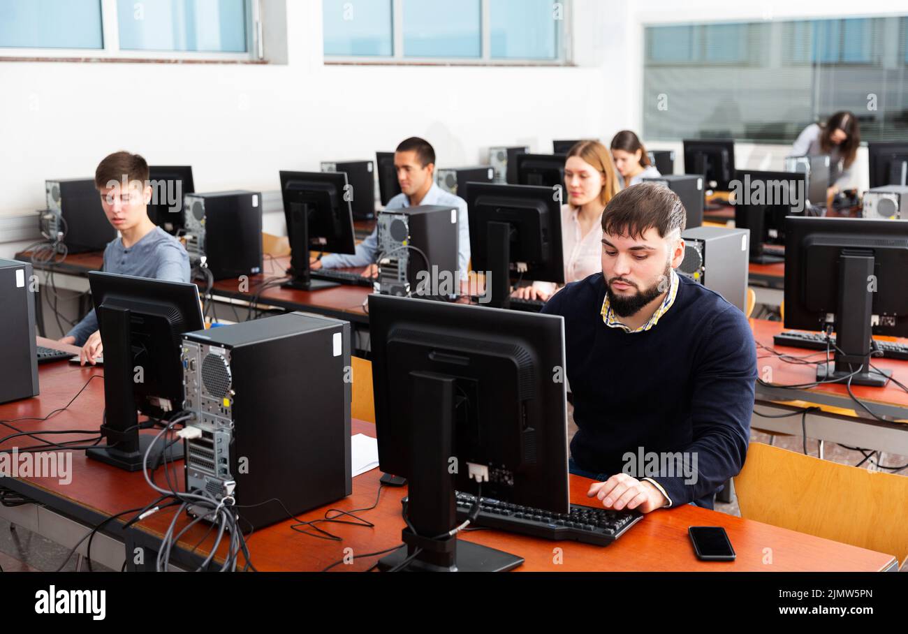 Group of people learning to use computers in classroom Stock Photo - Alamy