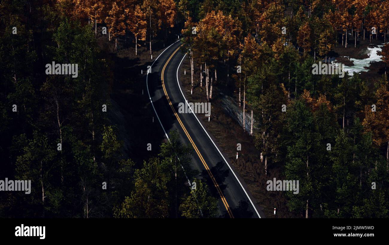 Aerial over a winding forest road in Finland during sunset Stock Photo