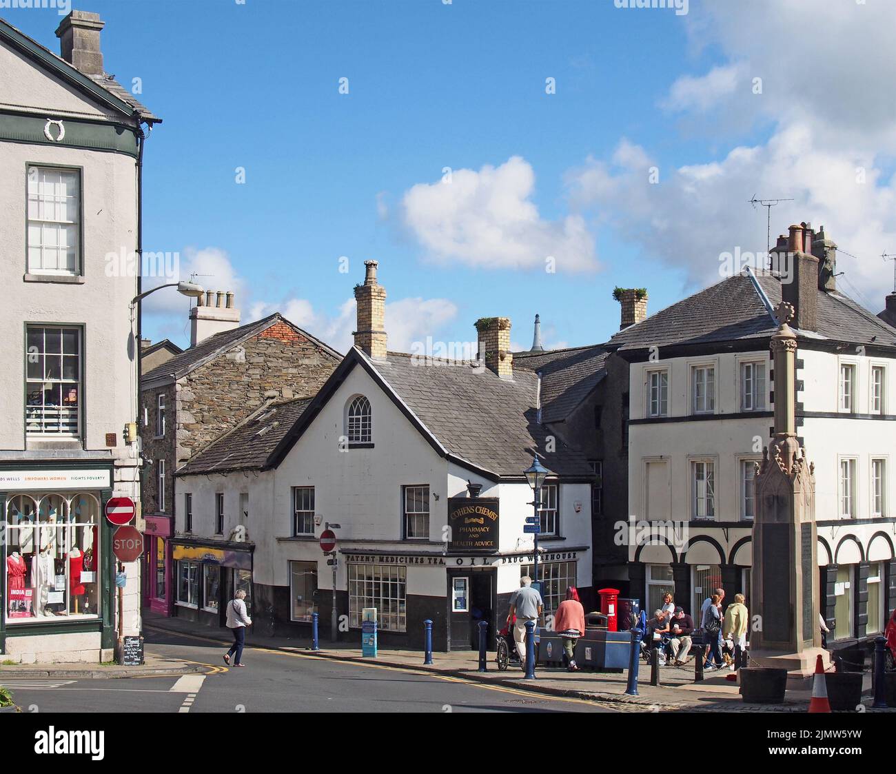 View of the town centre in ulverston cumbria with people walking past shops and war memorial Stock Photo