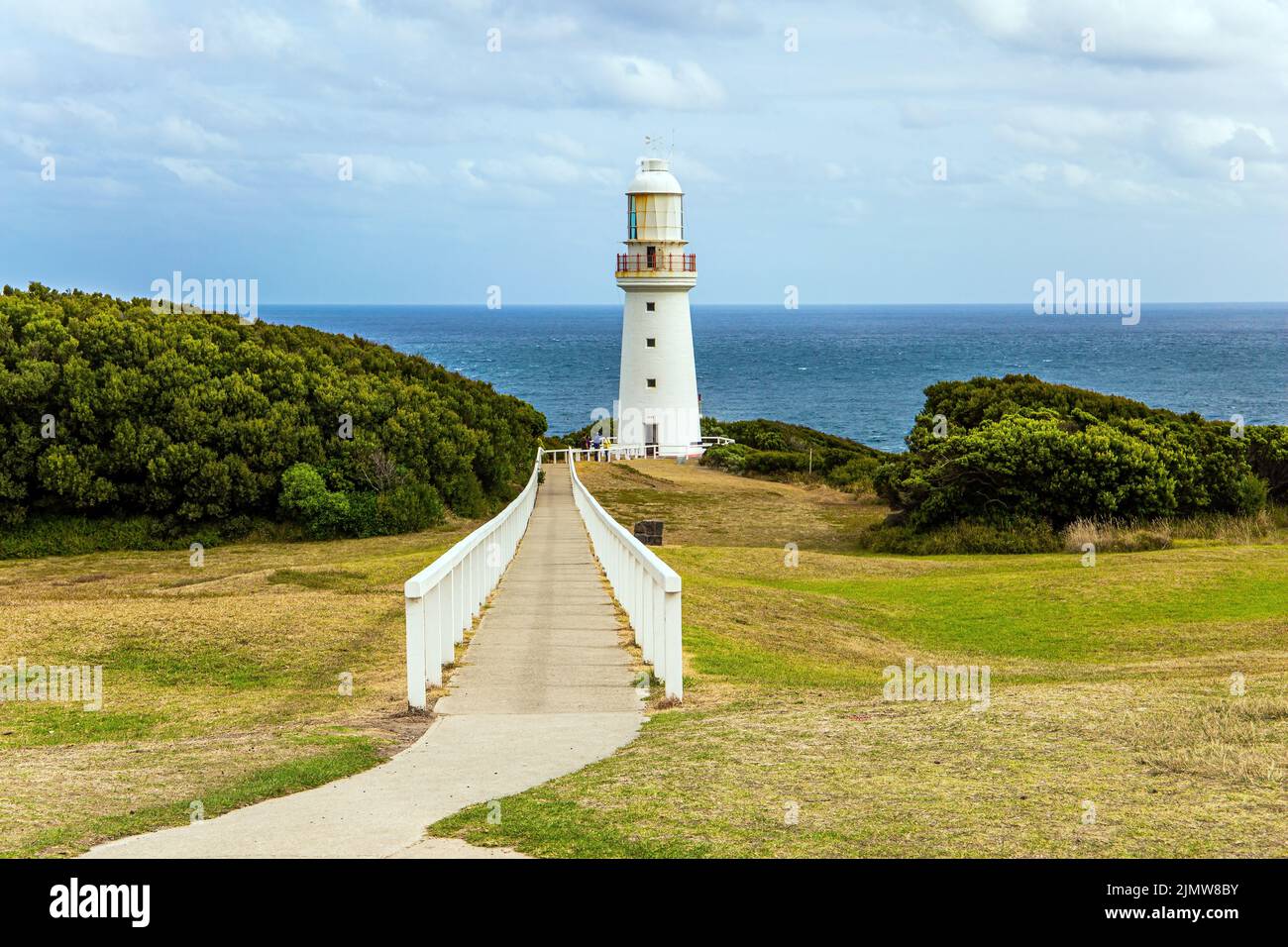 The path to the lighthouse is fenced with a railing Stock Photo
