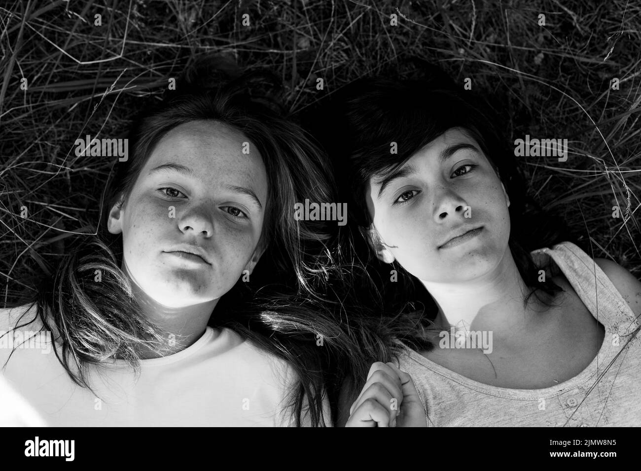 Two girls laughing together on grass Black and White Stock Photos ...