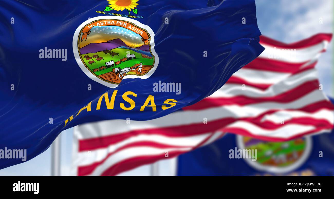 The Kansas state flag waving along with the national flag of the United States of America Stock Photo