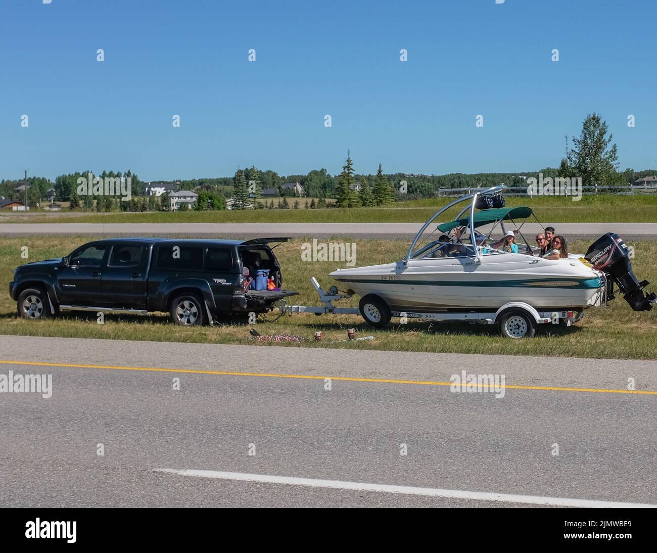 People with vehicle issues still managing to have some fun in the boat. Stock Photo