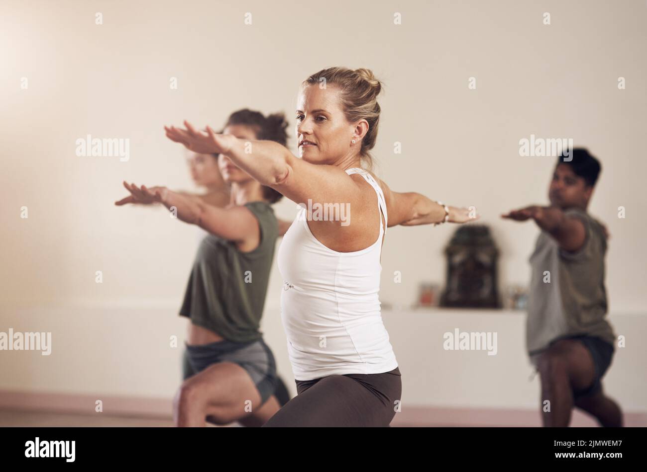 Weve all caught on the yoga bug. a group of young people working out together in a yoga class. Stock Photo