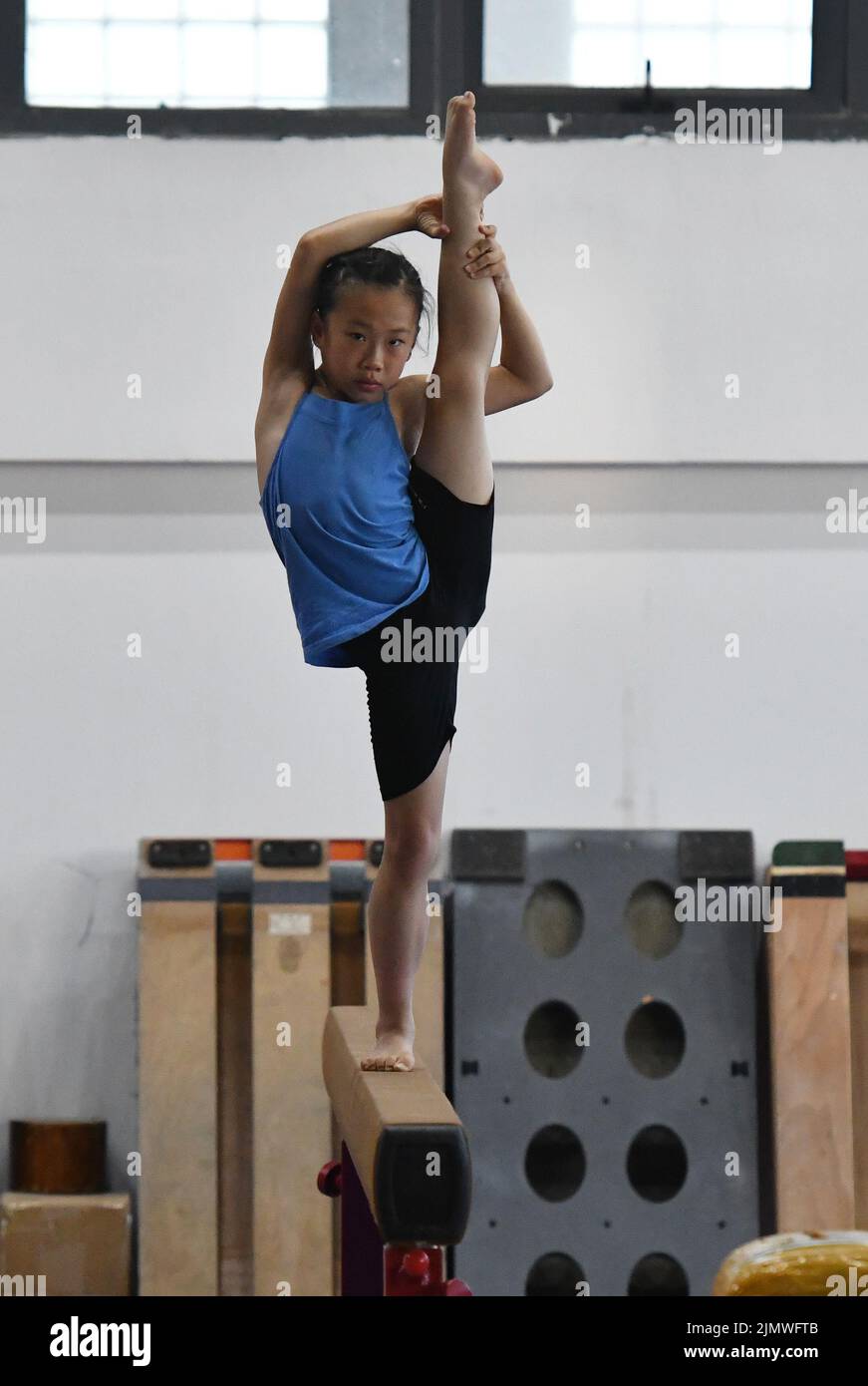 FUYANG, CHINA - AUGUST 7, 2022 - A child practices gymnastics moves at the gymnasium of Fuyang Vocational and Technical College in East China's Anhui Province, Aug 7, 2022. Currently, the team has more than a dozen children between the ages of 5 and 9 doing gymnastics. (Photo by CFOTO/Sipa USA) Stock Photo
