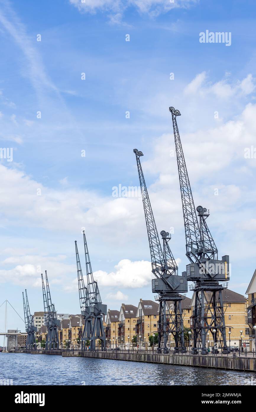 Old dockside cranes alongside a waterfront development Stock Photo