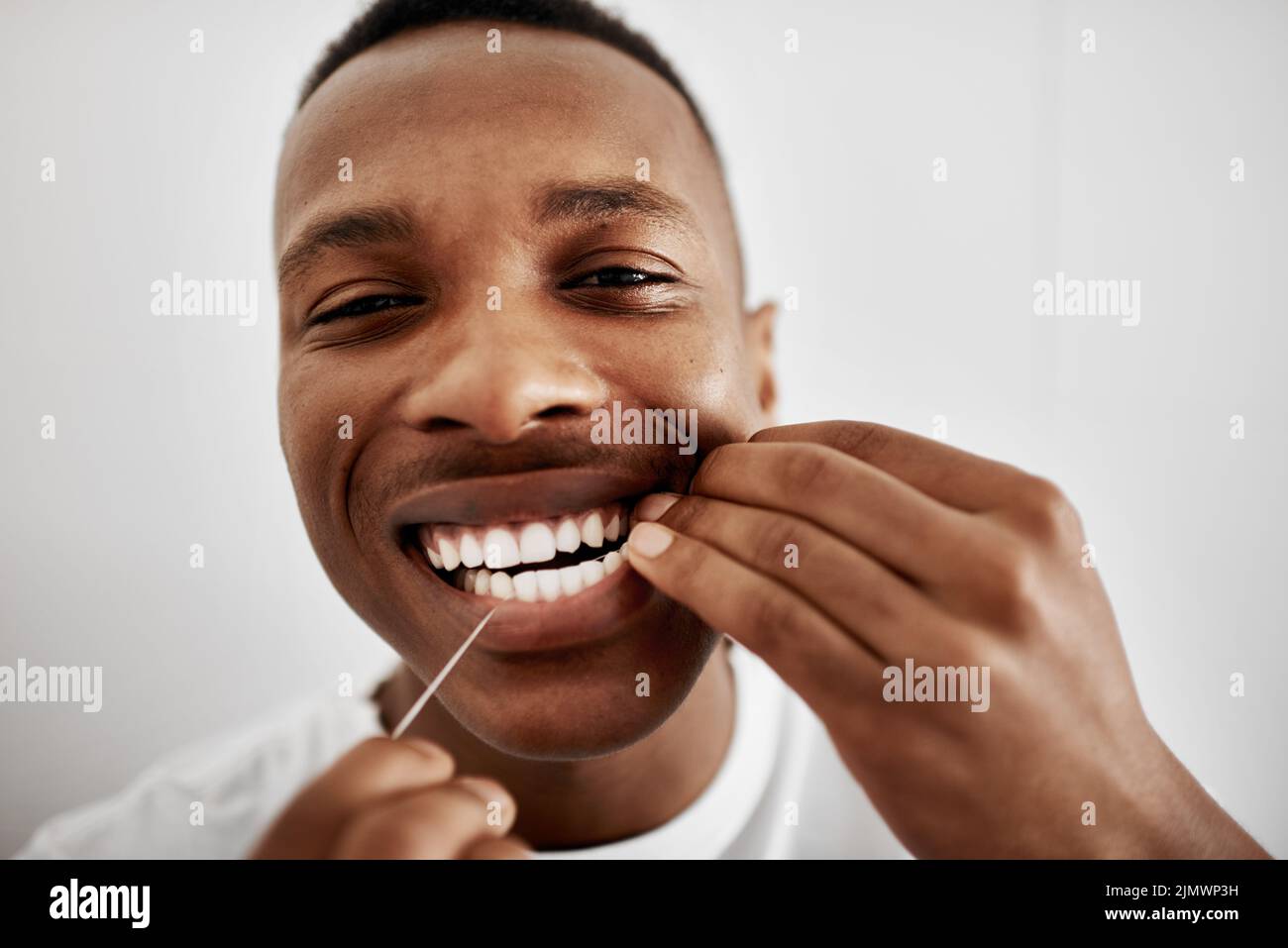 Floss For Cleaner Healthier Teeth A Young Man Flossing His Teeth In The Bathroom At Home Stock 