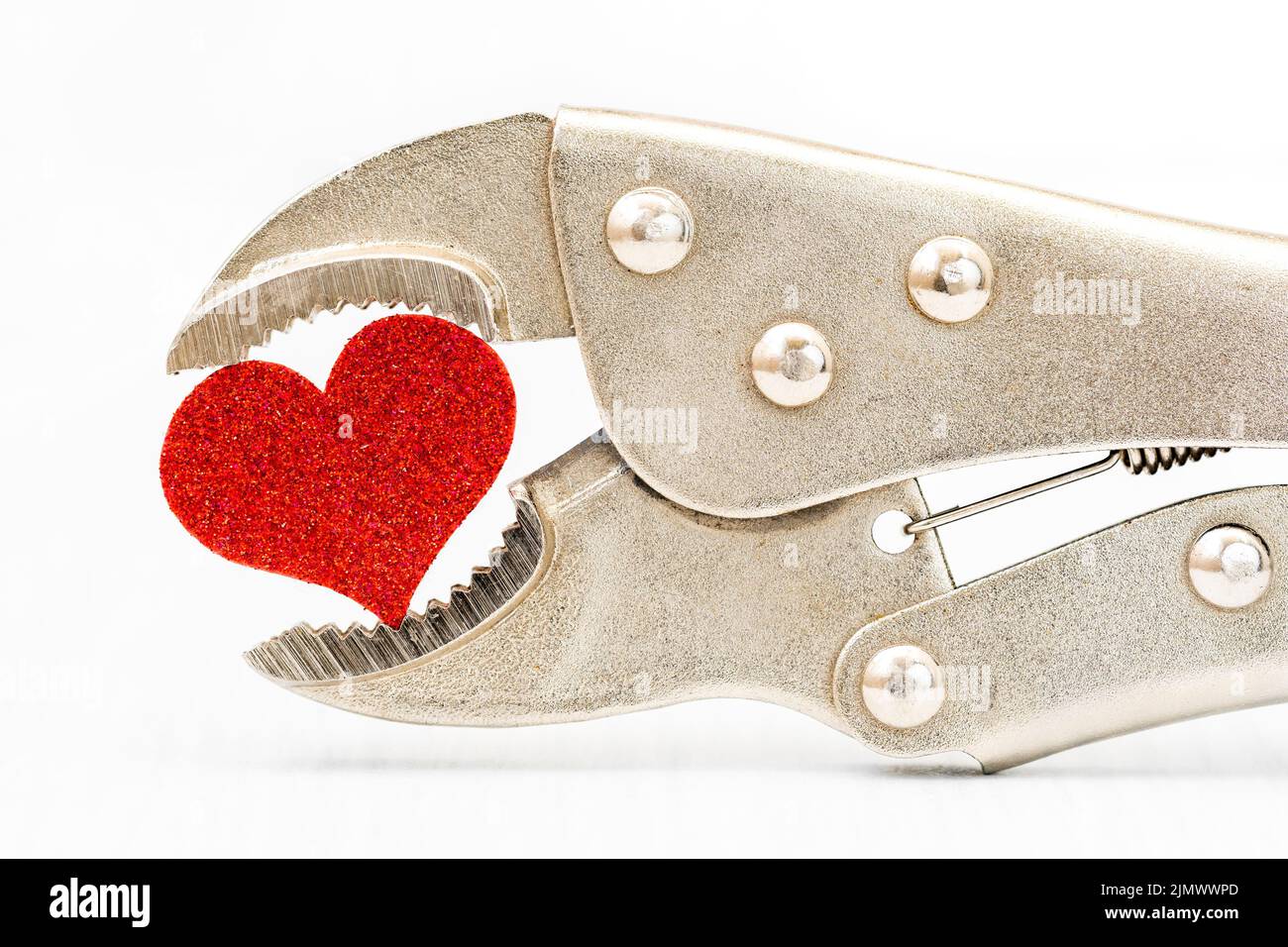 Heart clamped by pliers Stock Photo Alamy
