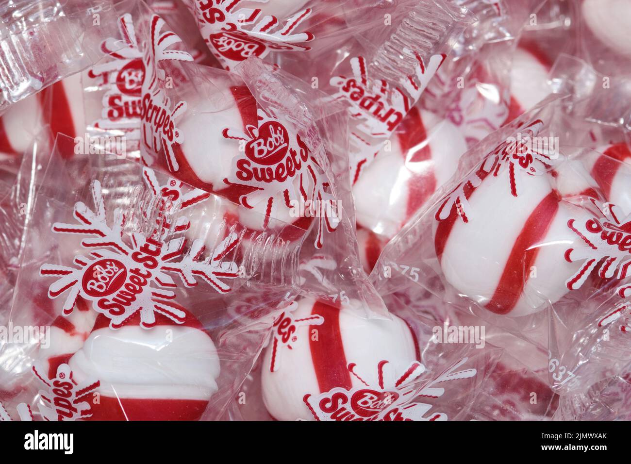 Houston, Texas USA 03-13-2022: Bobs Sweet Stripes hard peppermint candies in clear wrappers closeup scattered. Made by Ferrara Candy Company. Stock Photo