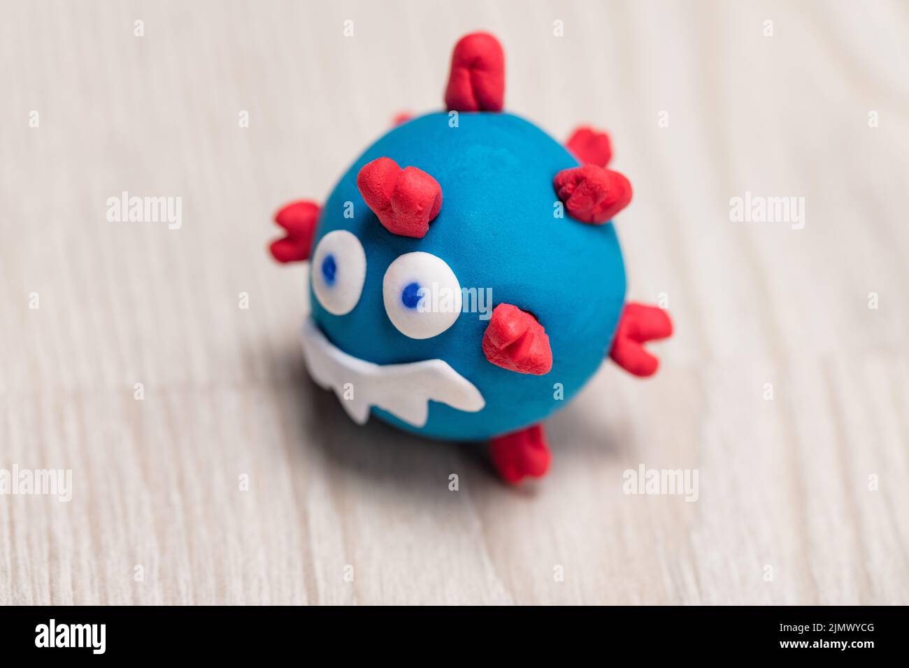 puppet depicting a small COVID-19 virus monster, smiling evilly and ready to strike... until its total defeat. Stock Photo