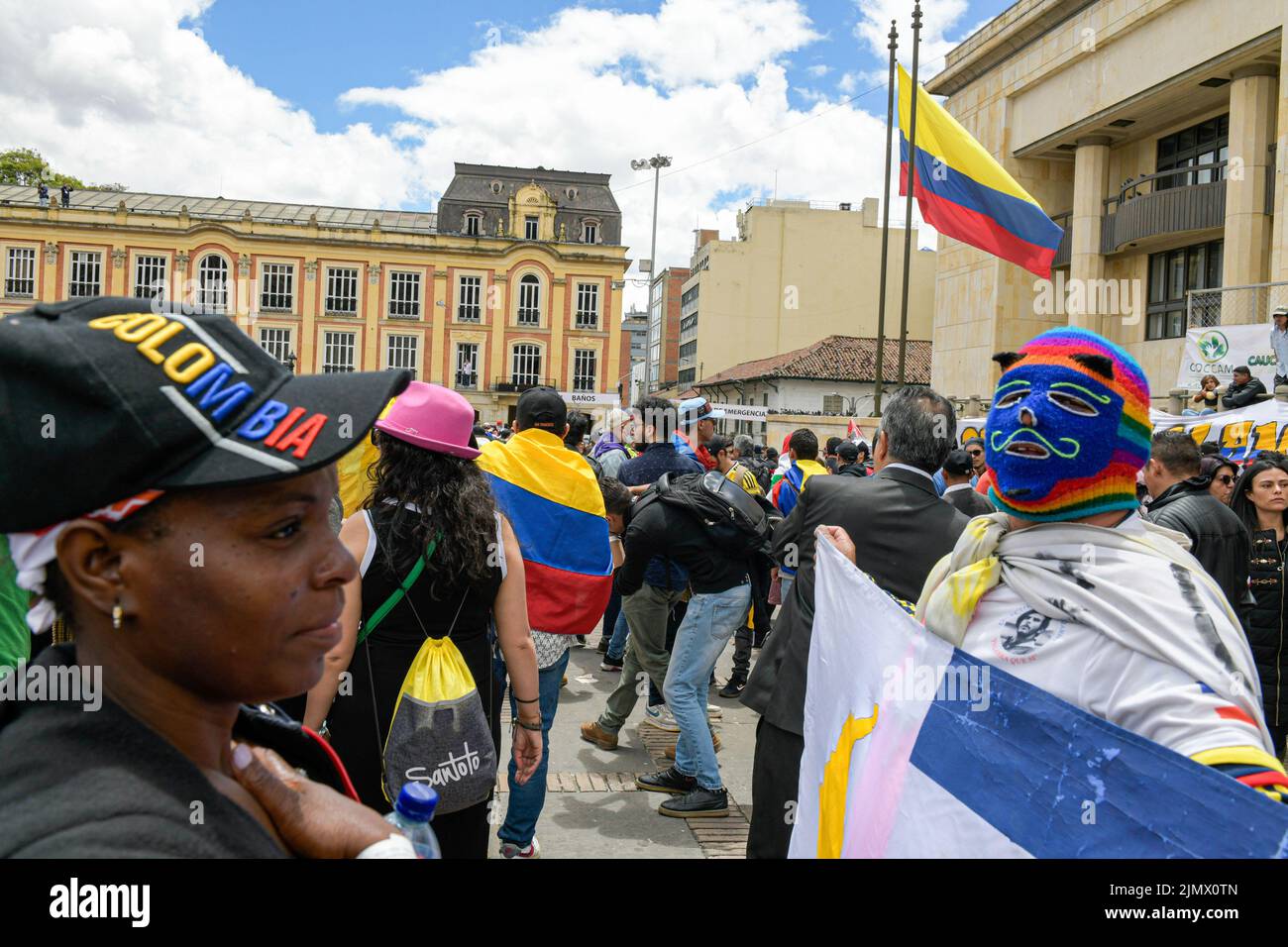 A group of people wrapped in Colombian flags awaits the arrival of the