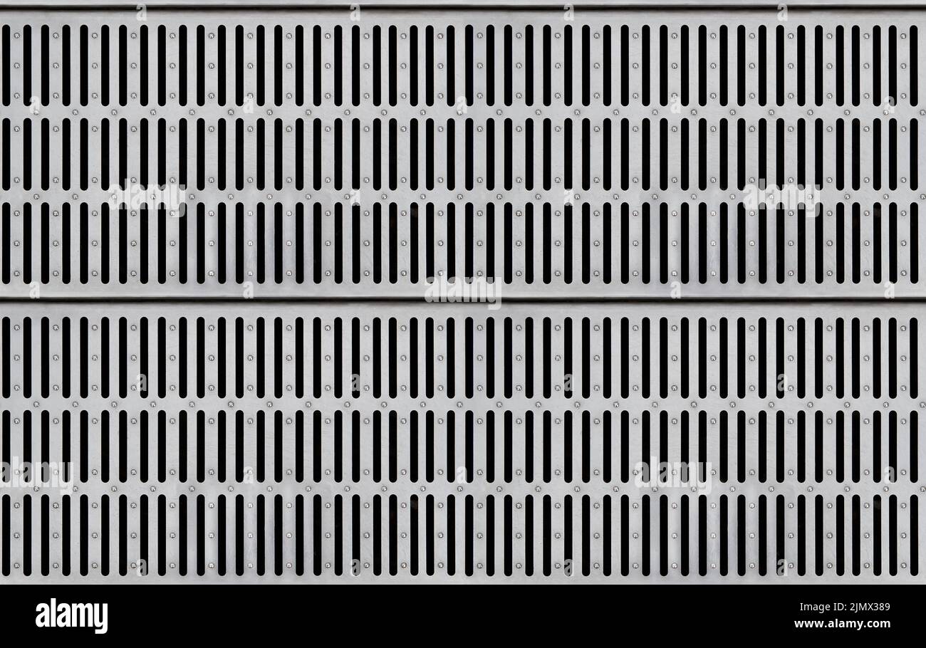 Seamless texture of silver-colored metal grate for water drain with long slits. Top view Stock Photo