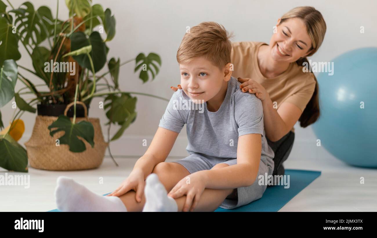 Full shot woman massaging kid Stock Photo