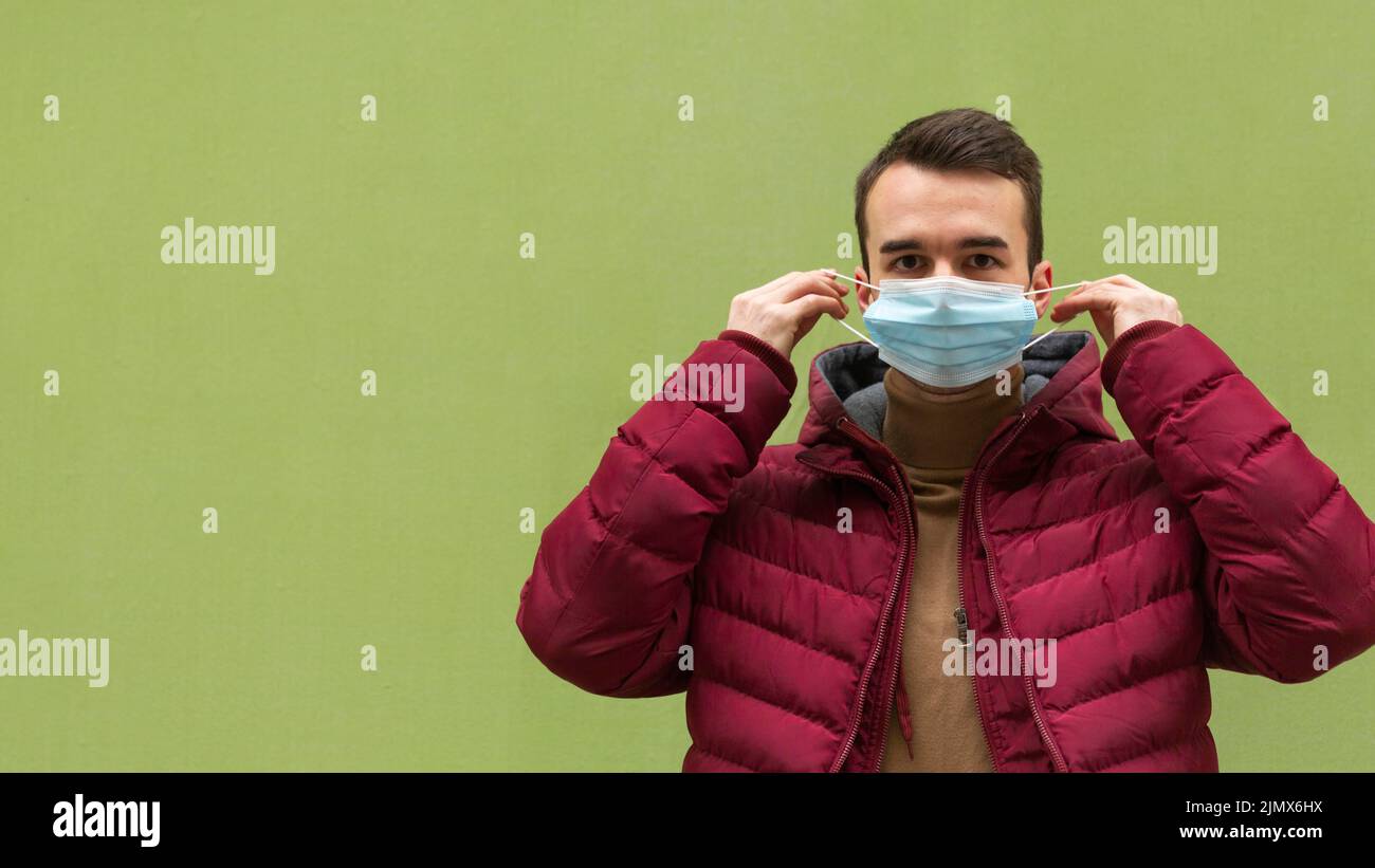 Front view man putting medical mask with copy space Stock Photo