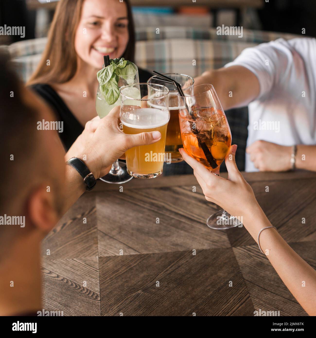 Friends sitting together bar toasting set drinks Stock Photo