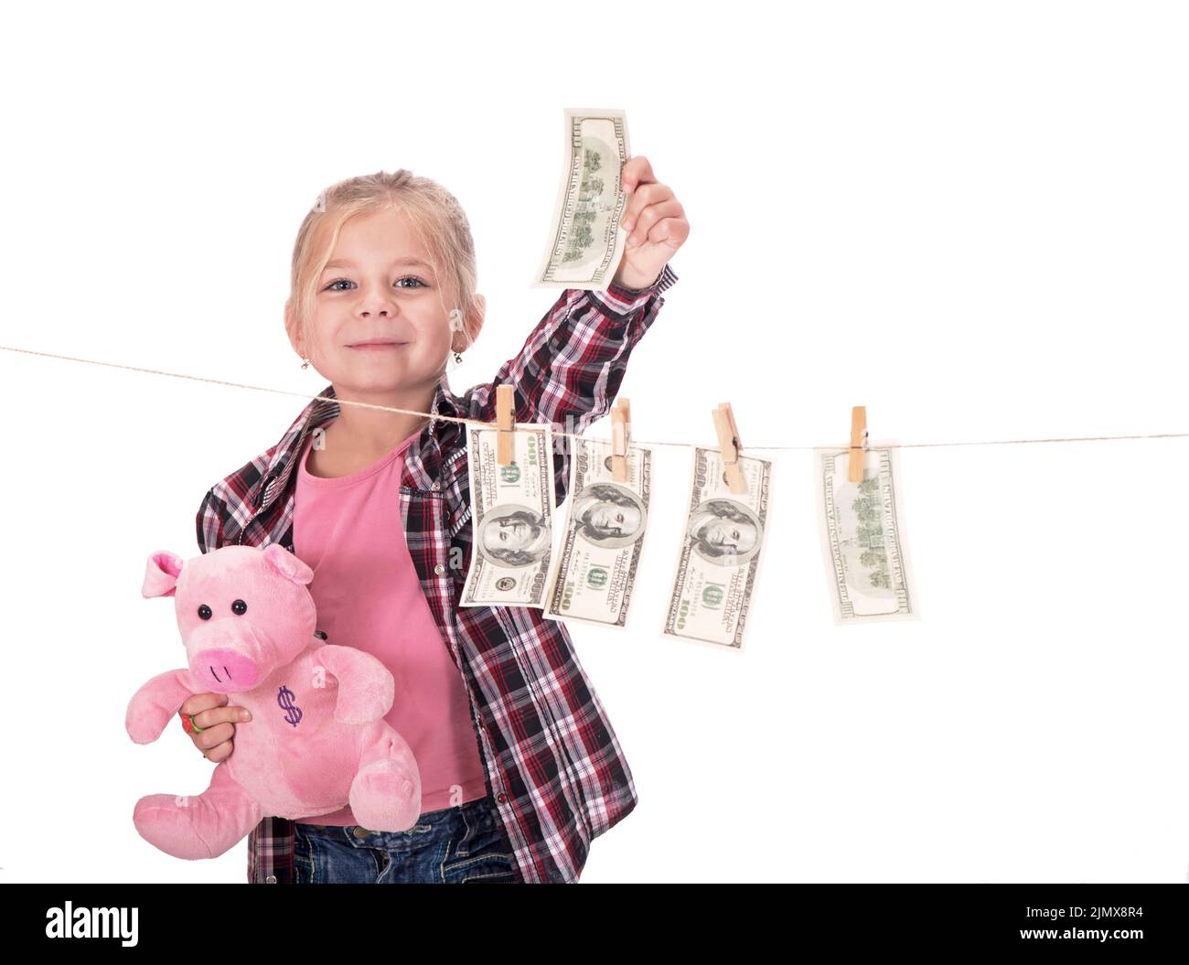 children and money. Girl with a piggy bank. Girl hanging dollar bills on a rope isolated on white background Stock Photo