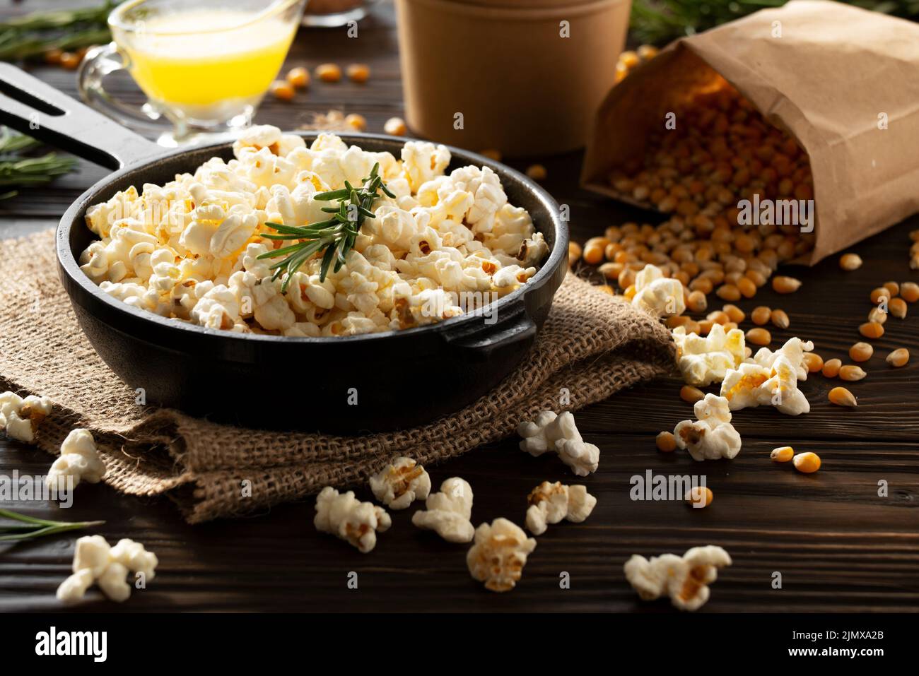Popcorn in cast iron skillet with paper bucket and melted butter aside