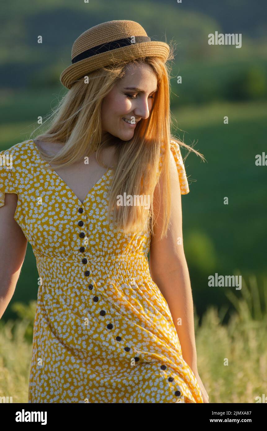 Young blond caucasian female model enjoying outdoor activity at meadow summer evening time Stock Photo