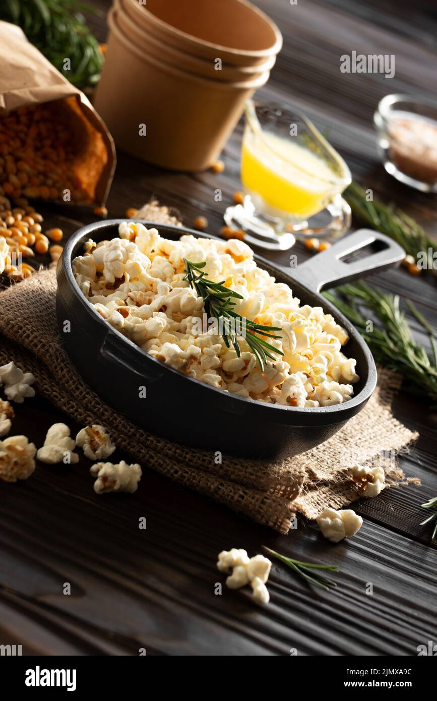 Popcorn in cast iron skillet with paper bucket and melted butter aside