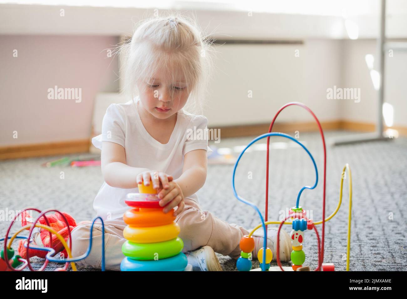Concentrated kid spending time with toys Stock Photo