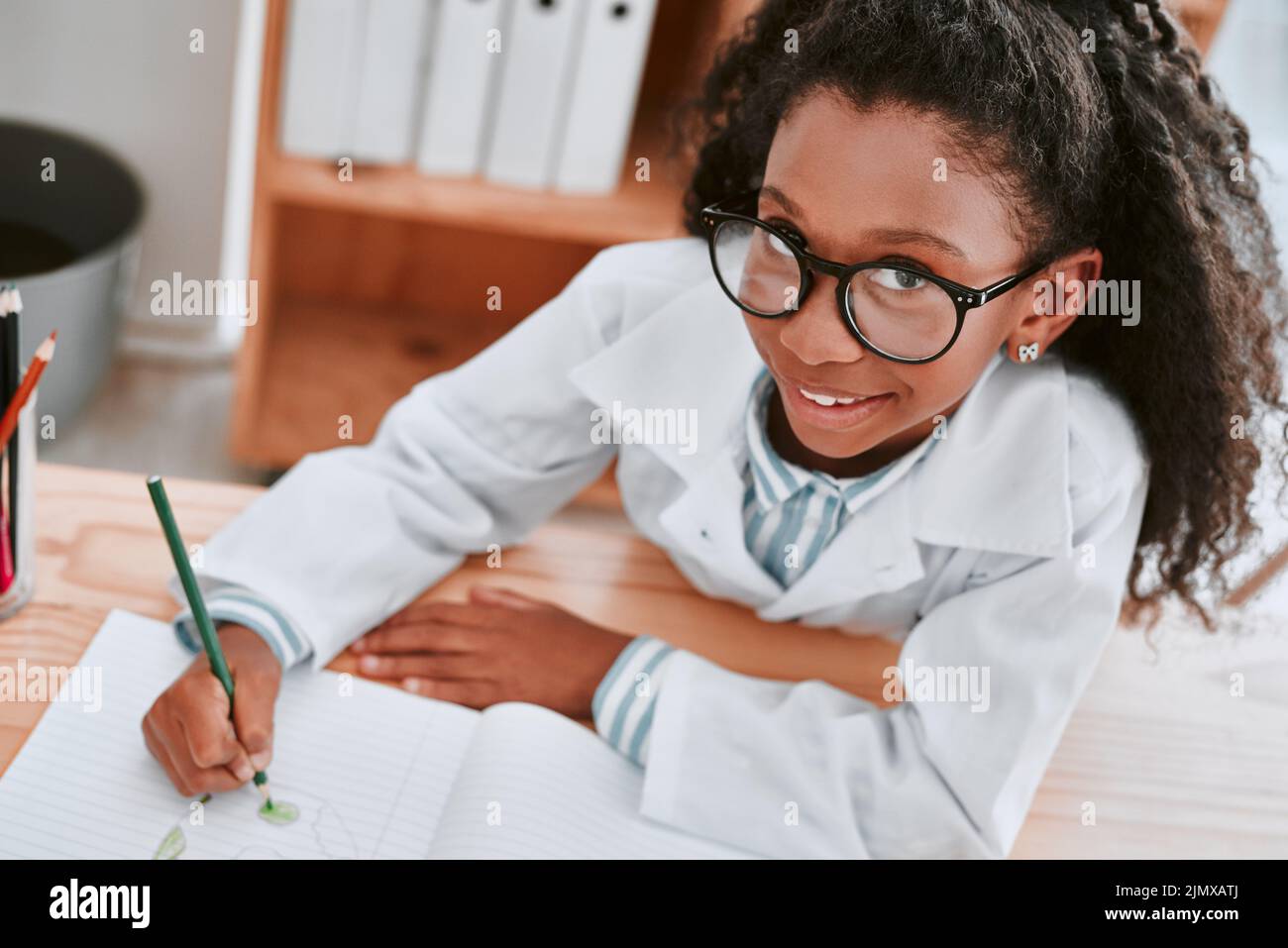 A-grades here I come. Portrait of an adorable young school girl drawing a diagram in her exercise book in science class at school. Stock Photo