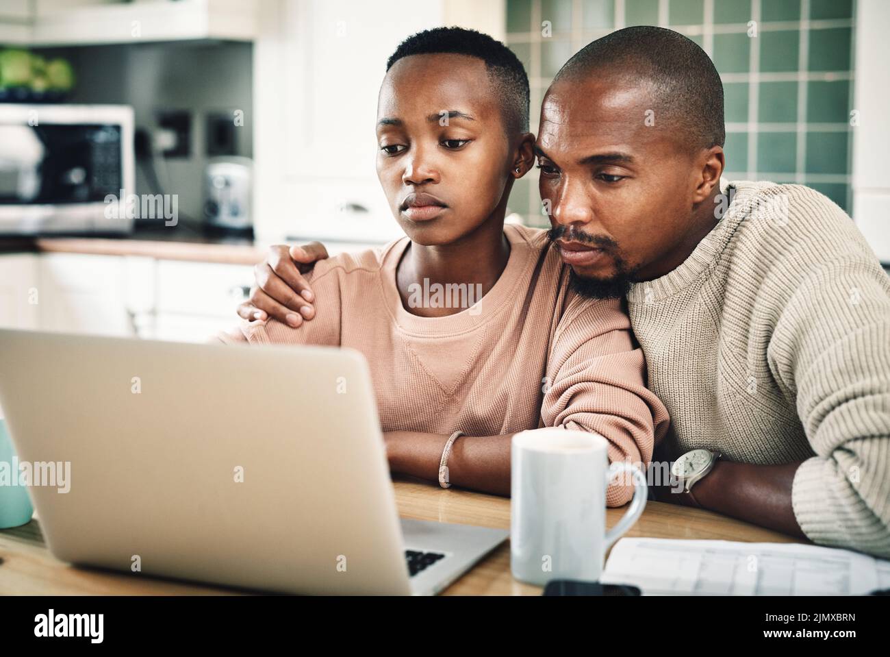 Were locked in and intrigued by the movie. a young couple using a laptop while relaxing together at home. Stock Photo