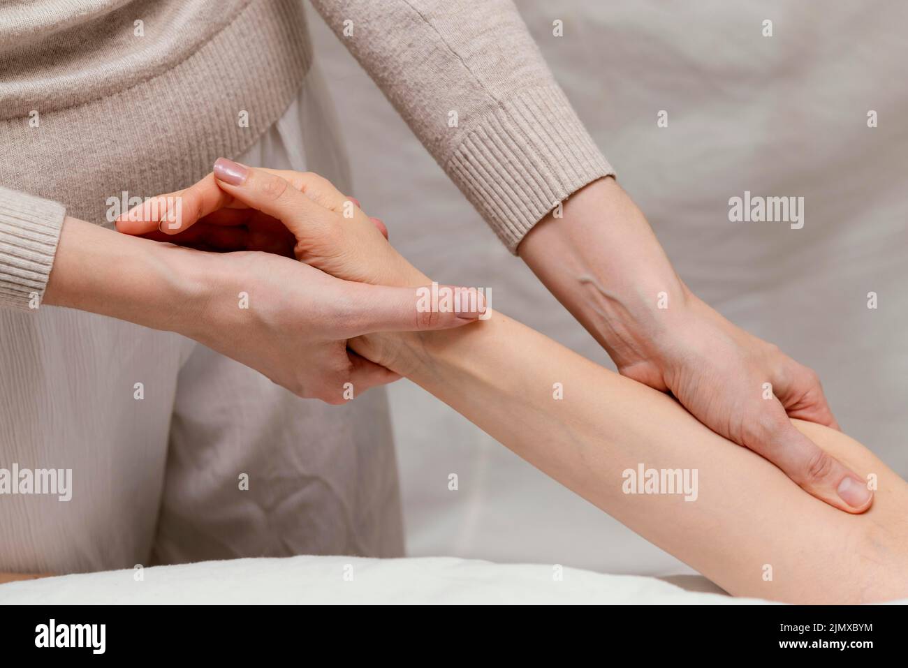 Close up therapist massaging patient s arm Stock Photo