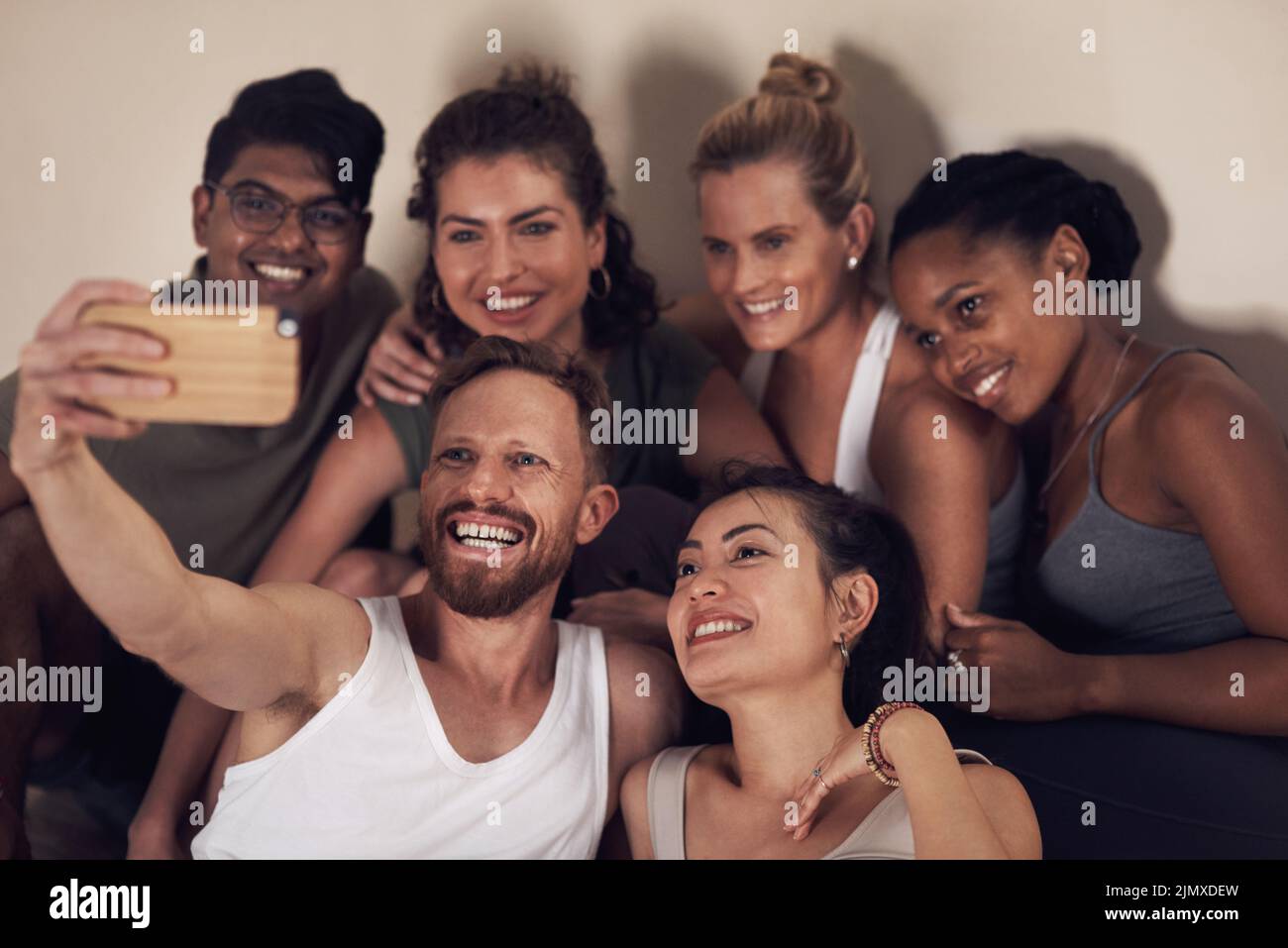 Post workout selfies are always the best. a group of young people taking selfies after working out together in a yoga class. Stock Photo