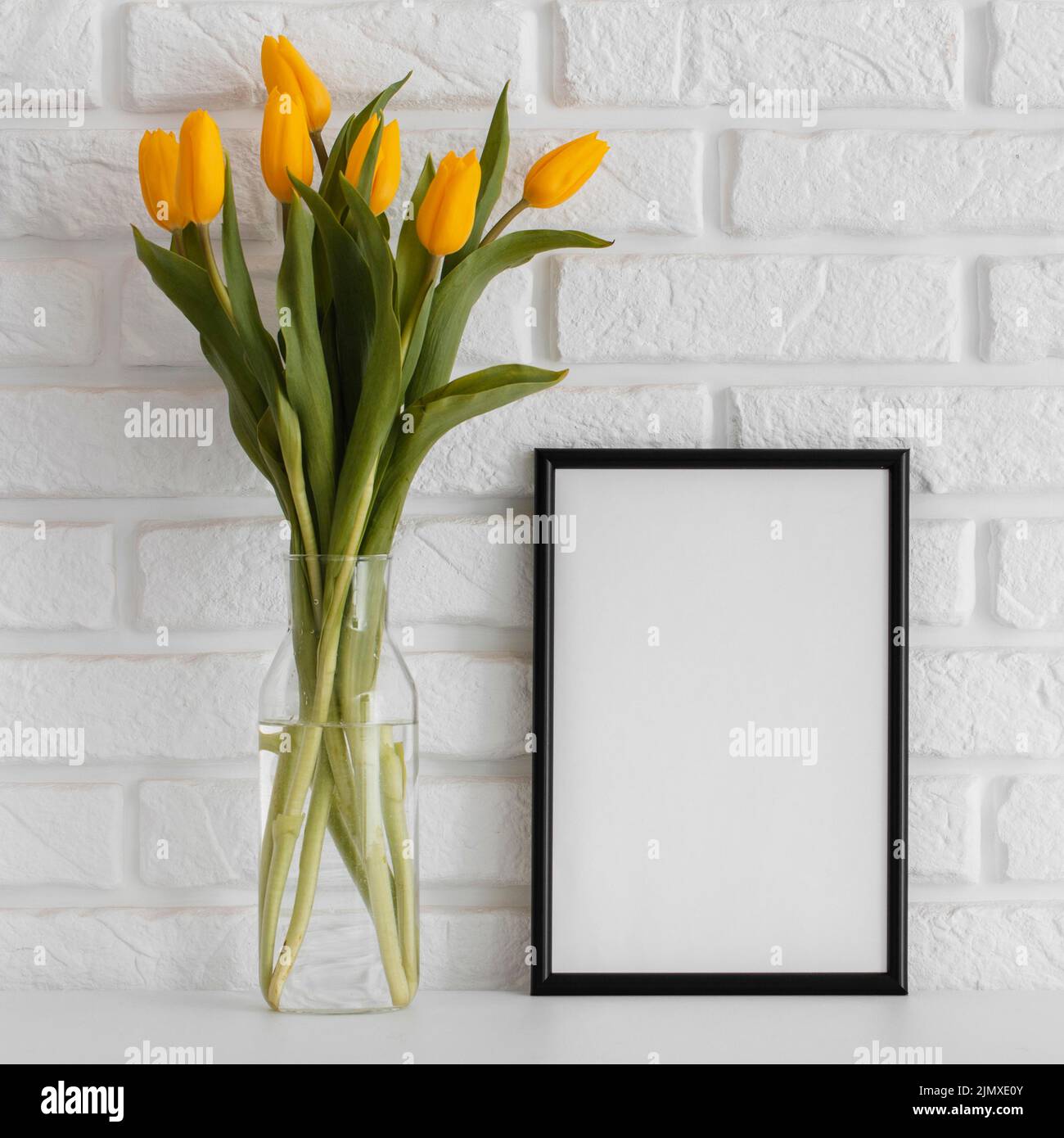 Bouquet tulips transparent vase with empty frame Stock Photo