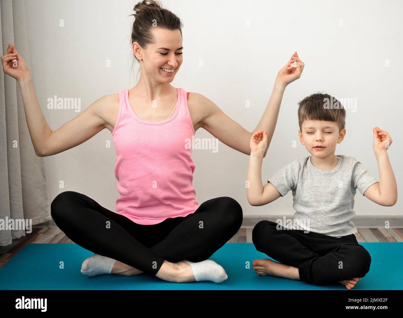 Active mother practicing yoga with her son Stock Photo