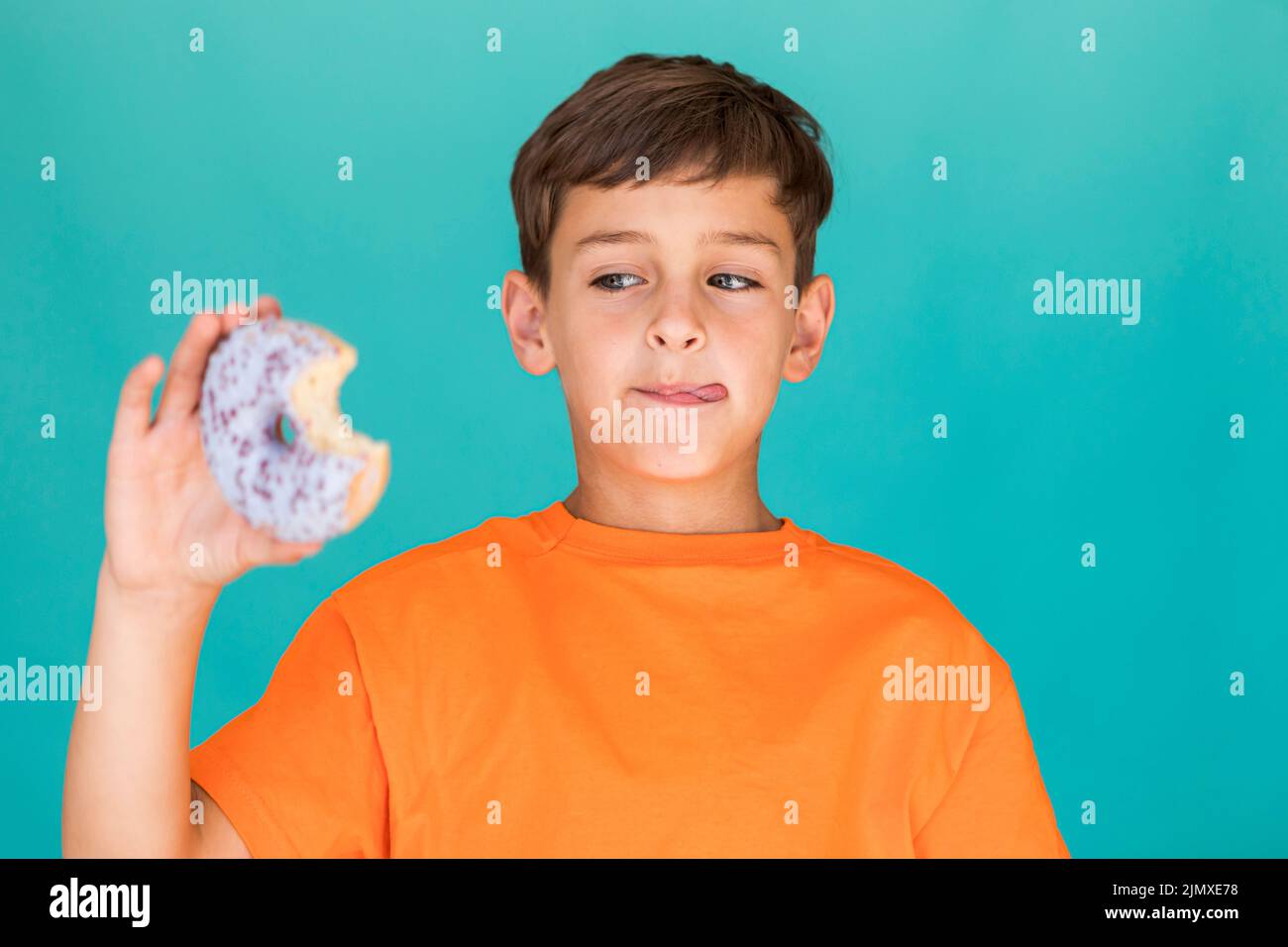 Boy looking delicious glazed doughnut Stock Photo