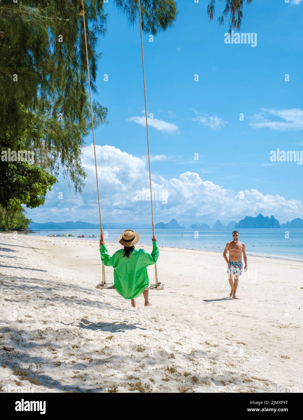 Couple men and woman on the beach of the tropical Island Naka Island near Phuket Thailand Stock Photo
