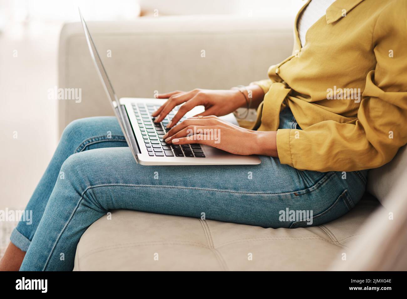 I am always creating. an unrecognizable businesswoman sitting on her couch and blogging from her laptop while at home. Stock Photo