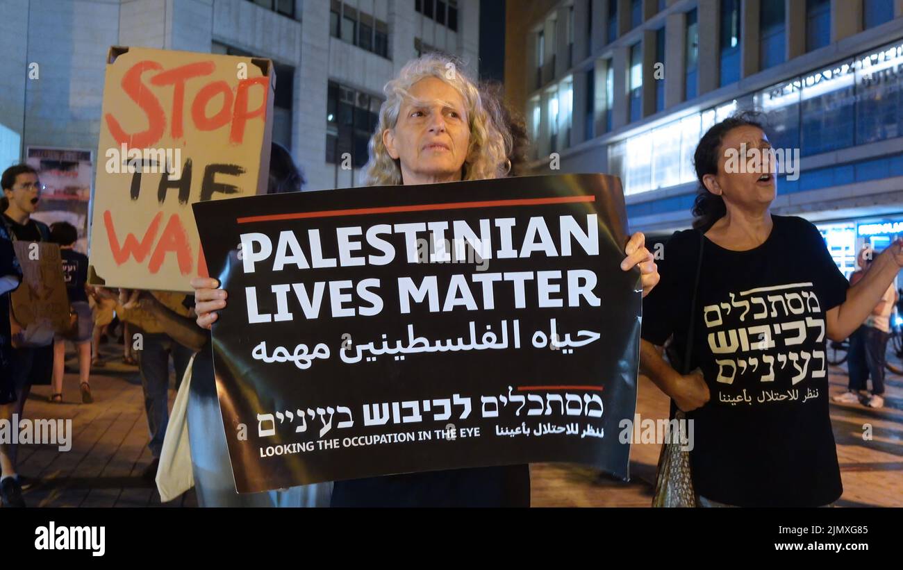 Israeli peace activists hold placards and shout slogans during a demonstration calling to end military operations against the Palestinian Islamic Jihad group in Gaza on August 6, 2022 in Jerusalem, Israel. Israeli army hit Gaza with air attacks while the militant Islamic Jihad group fired hundreds of rockets into Israel as a cross-border clash continued into a second day Stock Photo