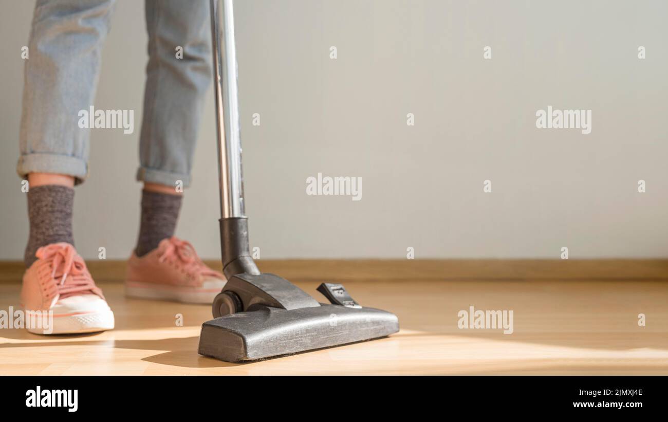 Woman using vacuum cleaner Stock Photo - Alamy