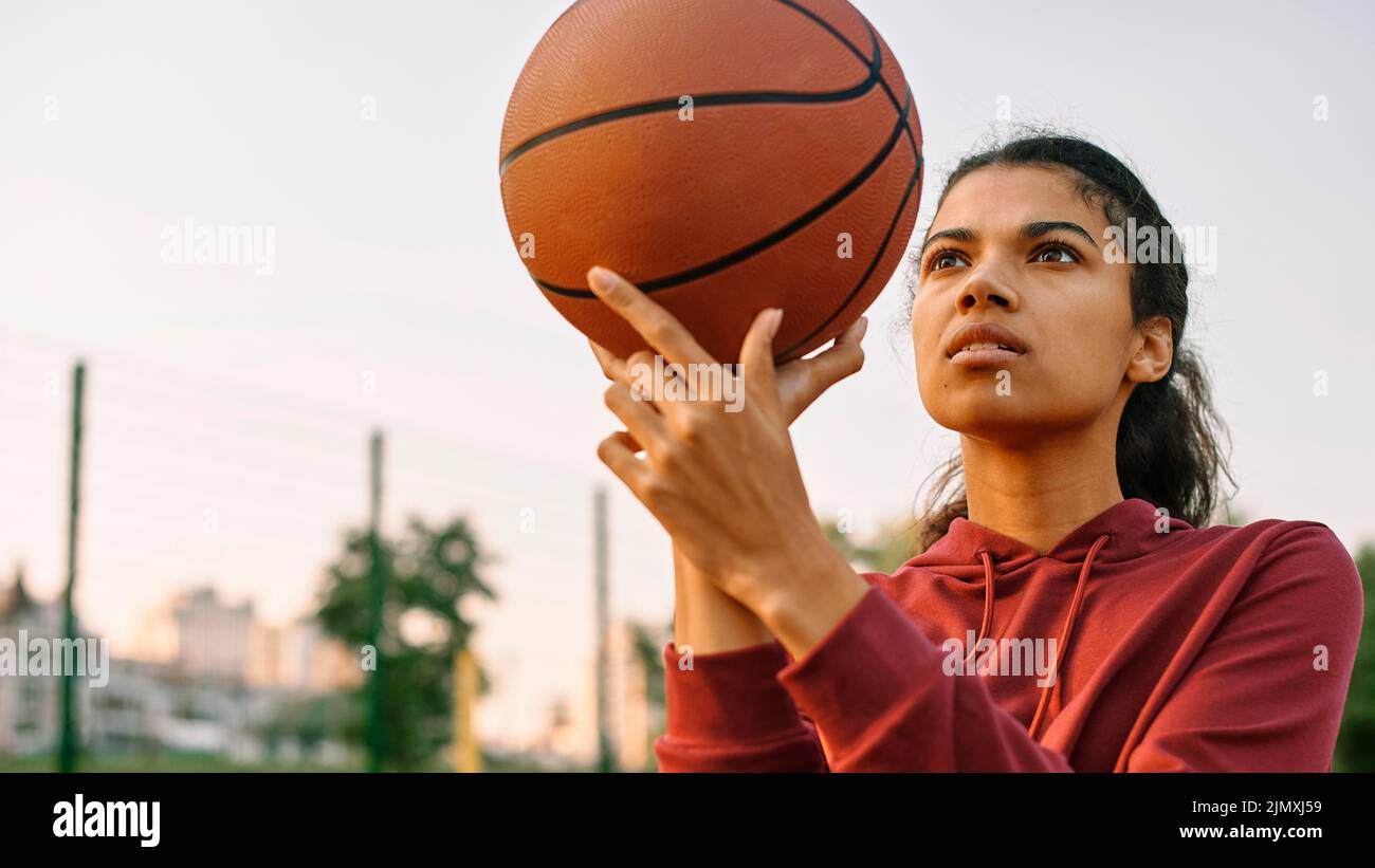 Young woman playing basketball outside Stock Photo