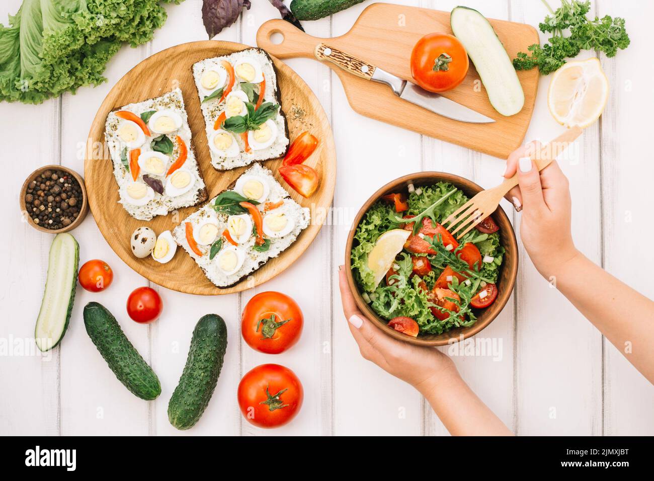 Woman putting fork into salad Stock Photo