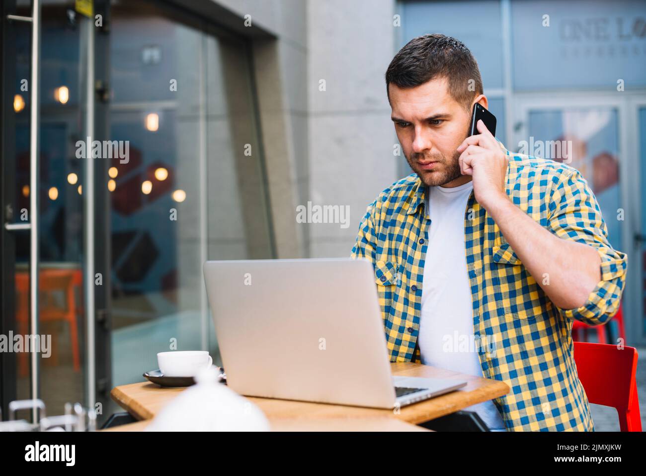 Young man talking phone seriously Stock Photo
