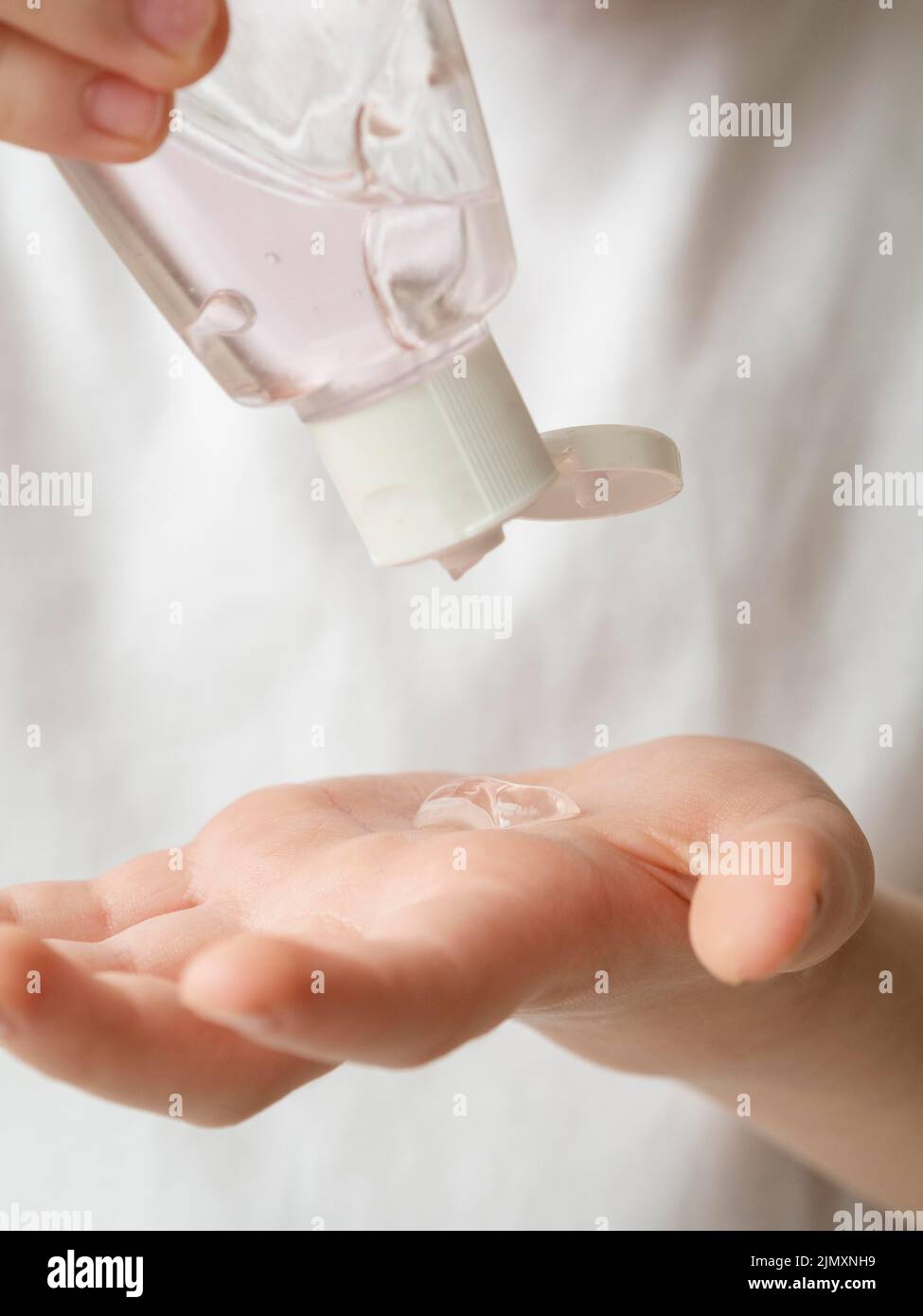 Front view child using hand sanitizer Stock Photo