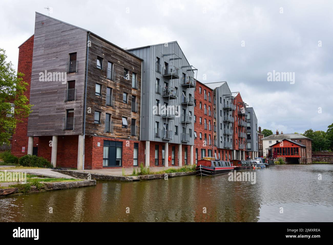 Chester, UK: Jul 3, 2022: A general scene of the Shropshire Union Canal in Chester, with canal boats moored outside a modern block of student accommod Stock Photo