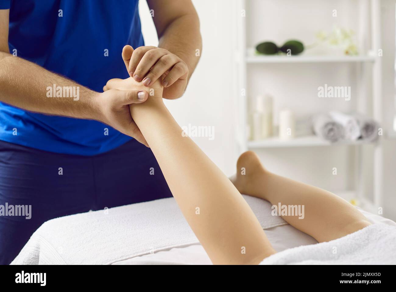 Professional in acupressure therapy and reflexology massaging young woman's foot Stock Photo